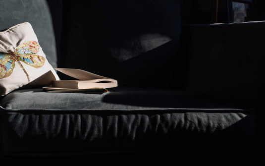 Stack of top university textbooks for 2026 on a sunlit sofa — Novabooks digital library